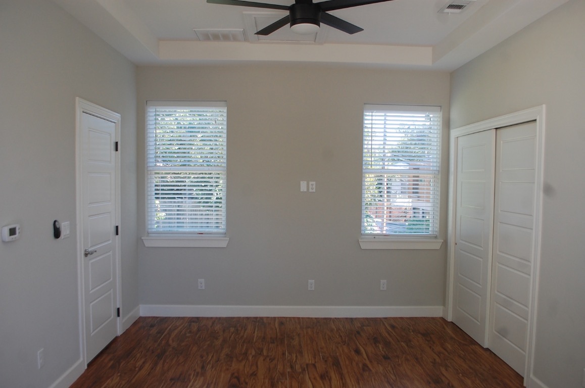 1707 Garden Street, Unit B Austin, TX 78702 - Photo 17 of 33 Unfurnished bedroom with a raised ceiling, a closet, dark wood-type flooring, and multiple windows