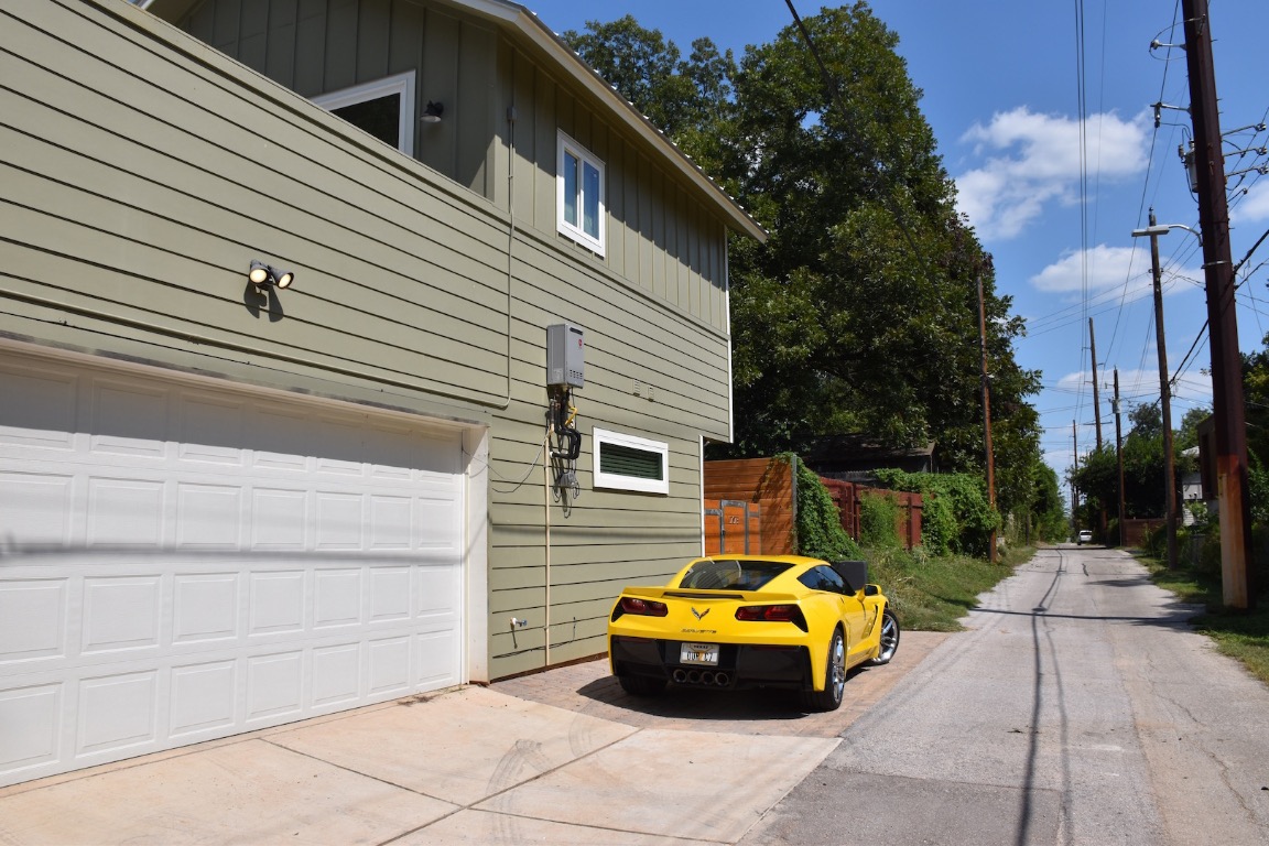 1707 Garden Street, Unit B Austin, TX 78702 - Photo 33 of 33 View of side of home featuring a garage, driveway, and board and batten siding