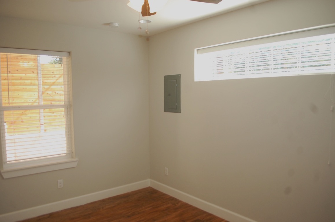 1707 Garden Street, Unit B Austin, TX 78702 - Photo 7 of 33 Empty room featuring dark wood-type flooring, electric panel, and ceiling fan