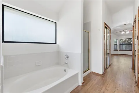 a bathroom with a double vanity sink a mirror a bathtub and shower