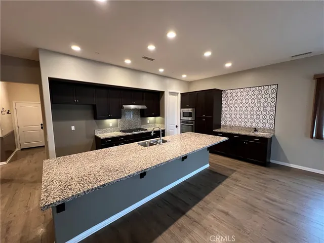 a large kitchen with kitchen island a sink stainless steel appliances and cabinets