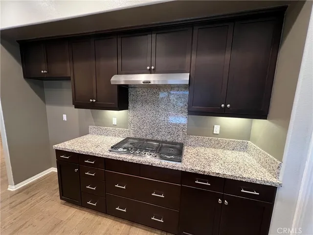 a kitchen with granite countertop wood cabinets and stainless steel appliances