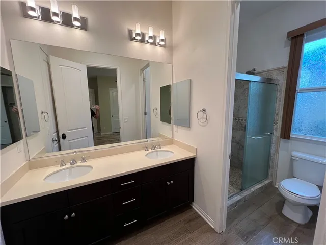 a spacious bathroom with a double vanity sink toilet and shower