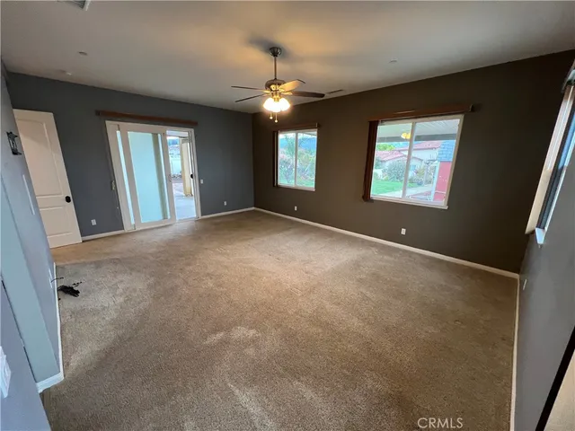 a view of a livingroom with a ceiling fan and window