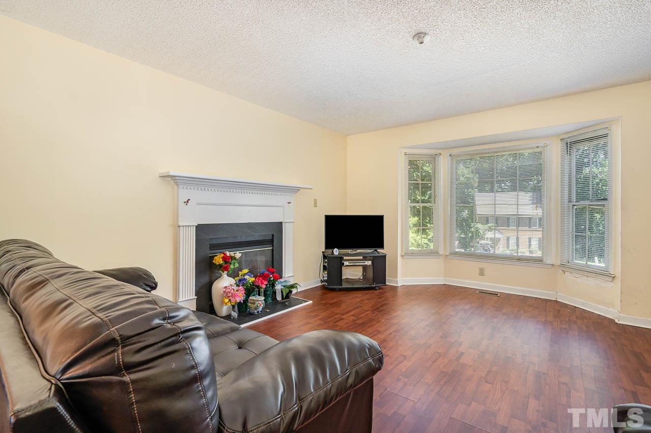 4608 Fisk Court Raleigh, NC 27604 - Photo 3 of 21 a living room with furniture a fireplace and a flat screen tv