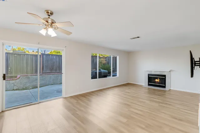 an empty room with fan and windows