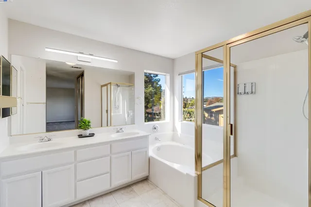 a spacious bathroom with a double vanity sink a mirror and a shower