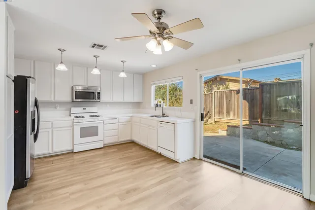 a kitchen with a white appliances a sink and a refrigerator