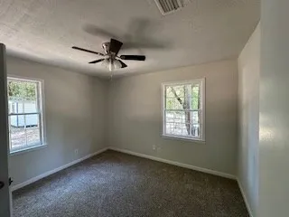 a view of a livingroom with a ceiling fan and window