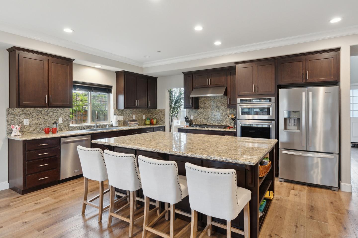 1471 Trinity Circle Hollister, CA 95023 - Photo 8 of 29 a kitchen with kitchen island granite countertop wooden floor and stainless steel appliances
