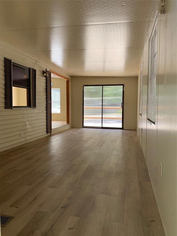 3000 Clarcona Road, Unit 723 Apopka, FL 32703 - Photo 13 of 14 an empty room with wooden floor and windows