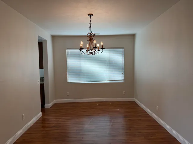 a window in an empty room with wooden floor
