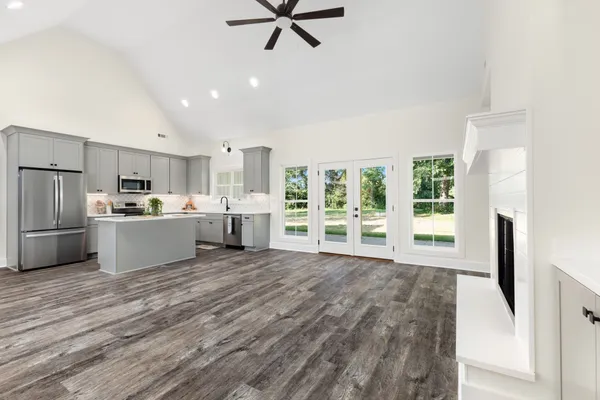 a view of a kitchen with refrigerator and wooden floor
