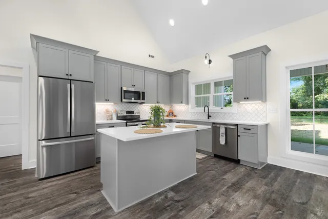 a kitchen with a refrigerator sink and cabinets