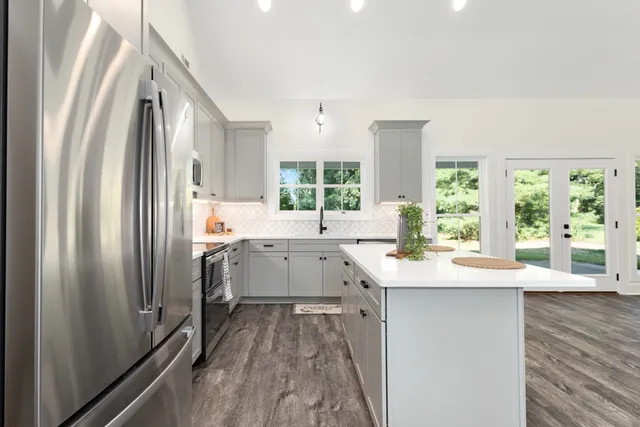 a kitchen with a sink window and refrigerator