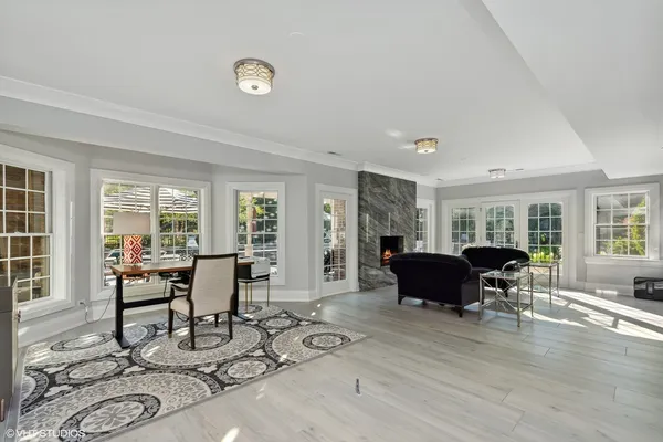 a view of patio with table and chairs under an umbrella with a barbeque