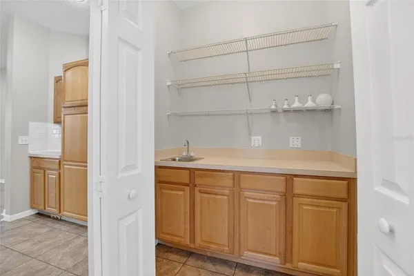 a kitchen with white cabinets and refrigerator