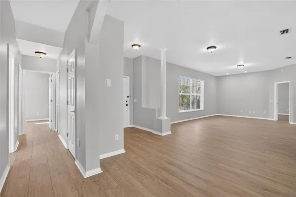 a view of a big room with wooden floor and windows