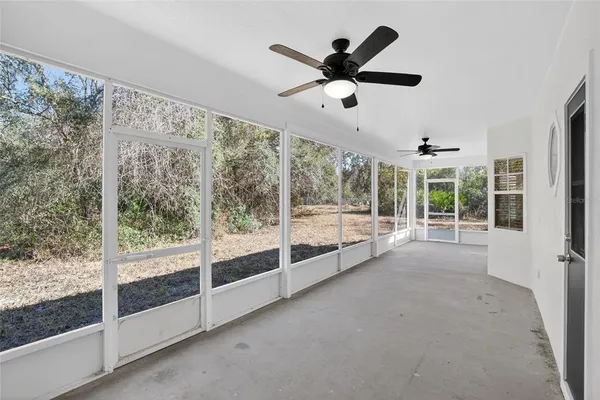 a view of a big room with wooden floor and windows