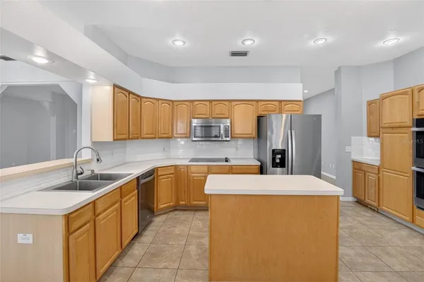 a kitchen with stainless steel appliances a refrigerator sink and cabinets