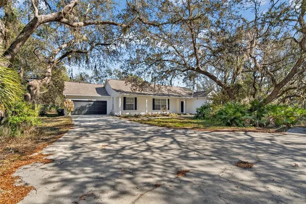a front view of a house with a trees