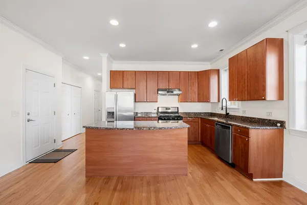 a large kitchen with stainless steel appliances wooden floors and wooden cabinets