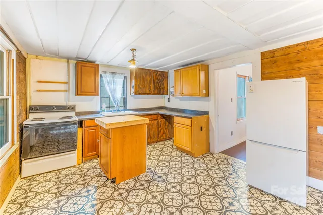 a kitchen with stainless steel appliances granite countertop a refrigerator and a stove