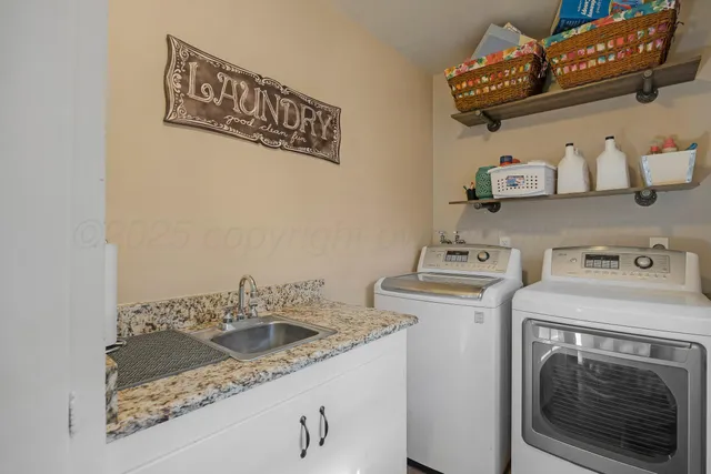 a utility room with sink dryer and washer