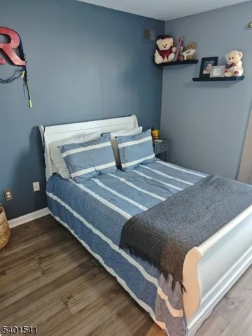 a bedroom with a bed and a wooden floor