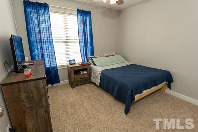 a bedroom with a bed and a flat tv screen on dresser
