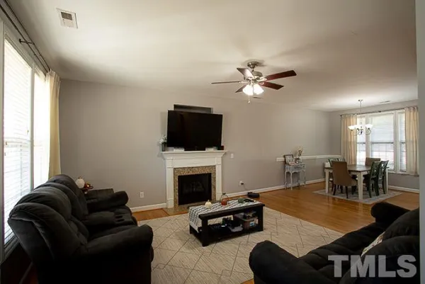 a living room with furniture a fireplace and a flat screen tv