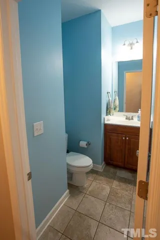 a bathroom with a toilet a sink a mirror and vanity