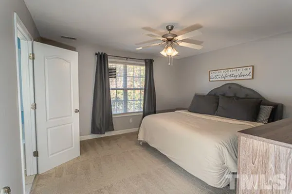 a bedroom with a large bed and a chandelier