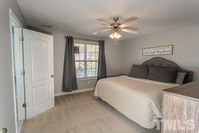 a bedroom with a large bed and a chandelier