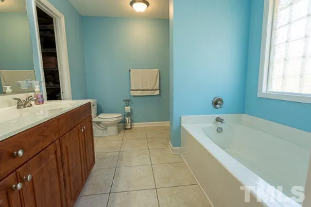 a bathroom with a tub sink and mirror