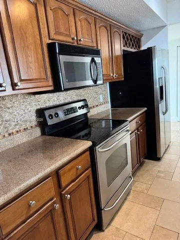 a kitchen with stainless steel appliances granite countertop a stove microwave and refrigerator