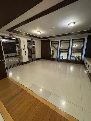 a view of an empty room with a fireplace and a window