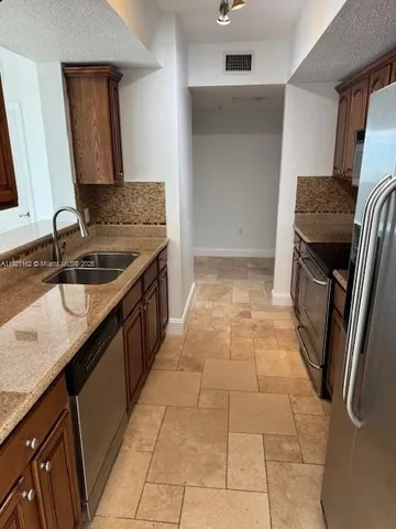 a kitchen with a sink a refrigerator and a stove