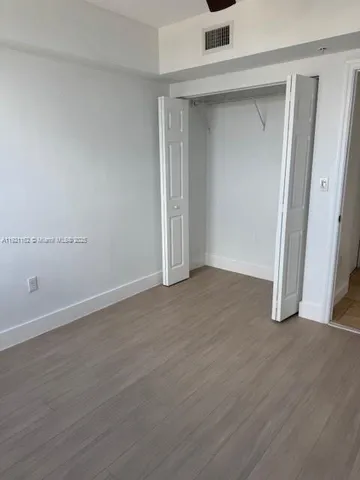 an empty room with wooden floor and closet