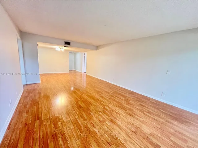 a view of an empty room and wooden floor