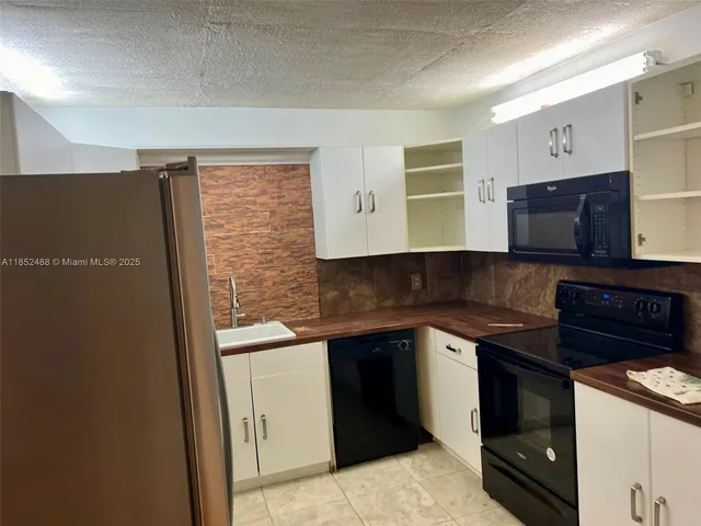 a kitchen with stainless steel appliances granite countertop a stove and a refrigerator