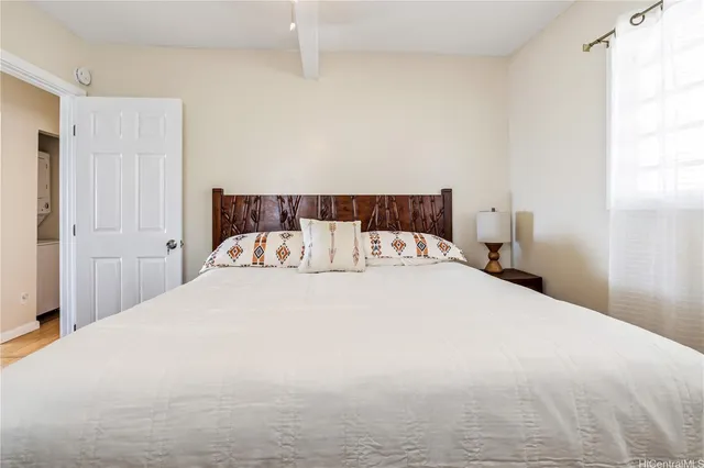 a large bed sitting in a bedroom next to a window
