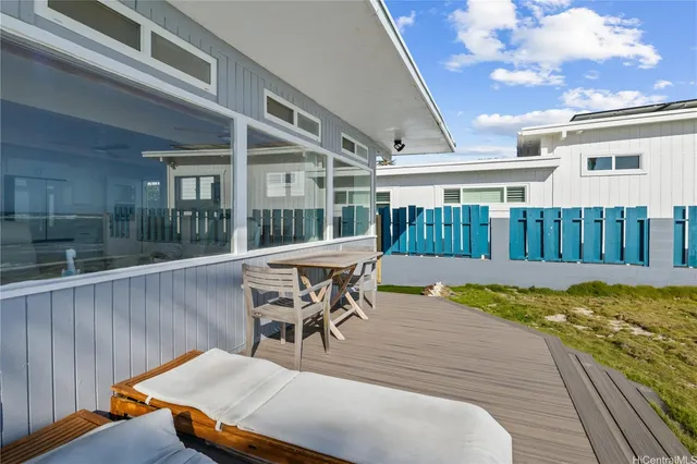a view of a patio with a table chairs and wooden fence