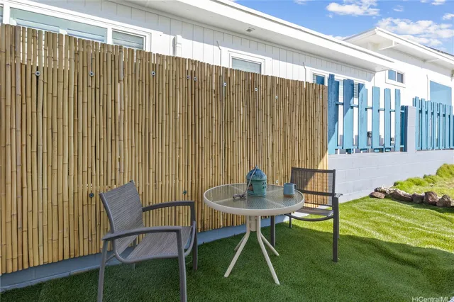 a backyard of a house with table and chairs
