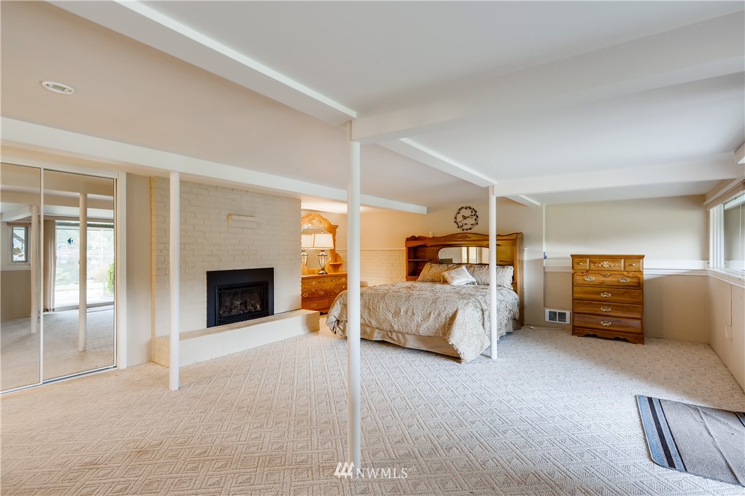 8716 East Lake Cochran Road Monroe, WA 98272 - Photo 13 of 29 a bedroom with furniture and a fireplace