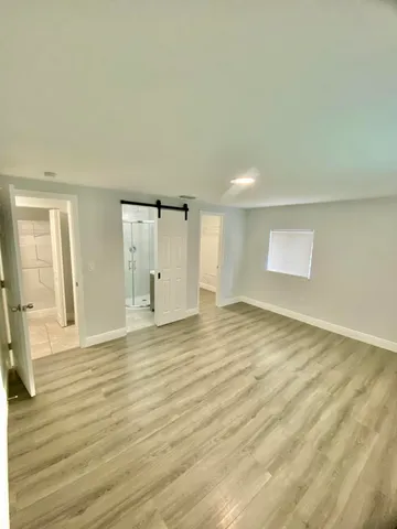 a view of an empty room with wooden floor