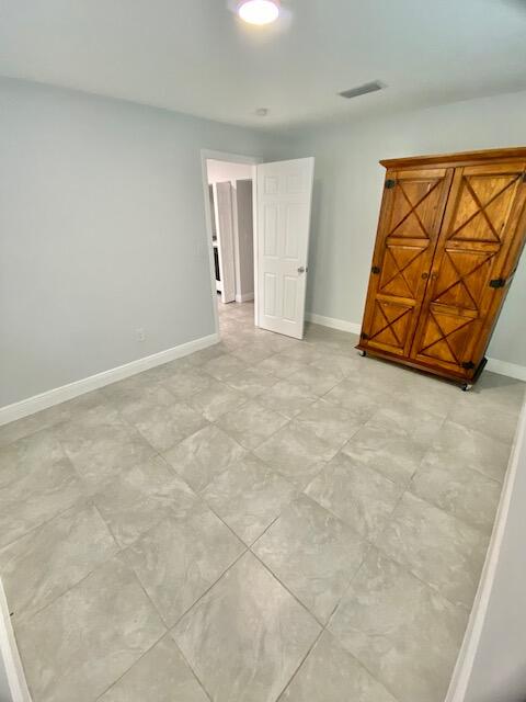 4344 Mars Avenue West Palm Beach, FL 33406 - Photo 8 of 11 an empty room with a chandelier fan and windows