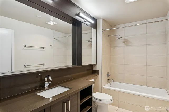 a bathroom with a sink a toilet a mirror and shower