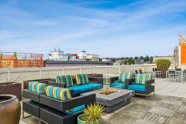 a view of roof deck with couches and potted plants