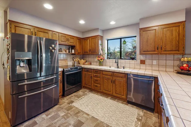 a large kitchen with kitchen island granite countertop a large window in it